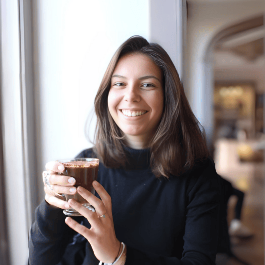 Lea Kohler, Frau, Mitte 20, die eine Tasse Kaffee hält.